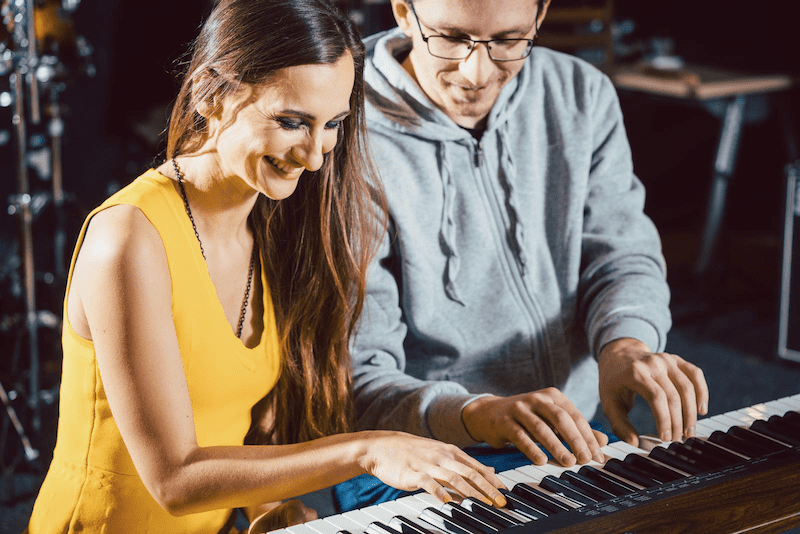 A man and a woman playing the piano,