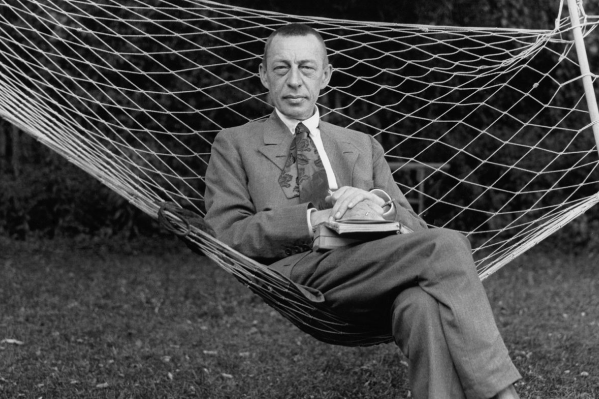 Man in suit relaxing on outdoor rope hammock