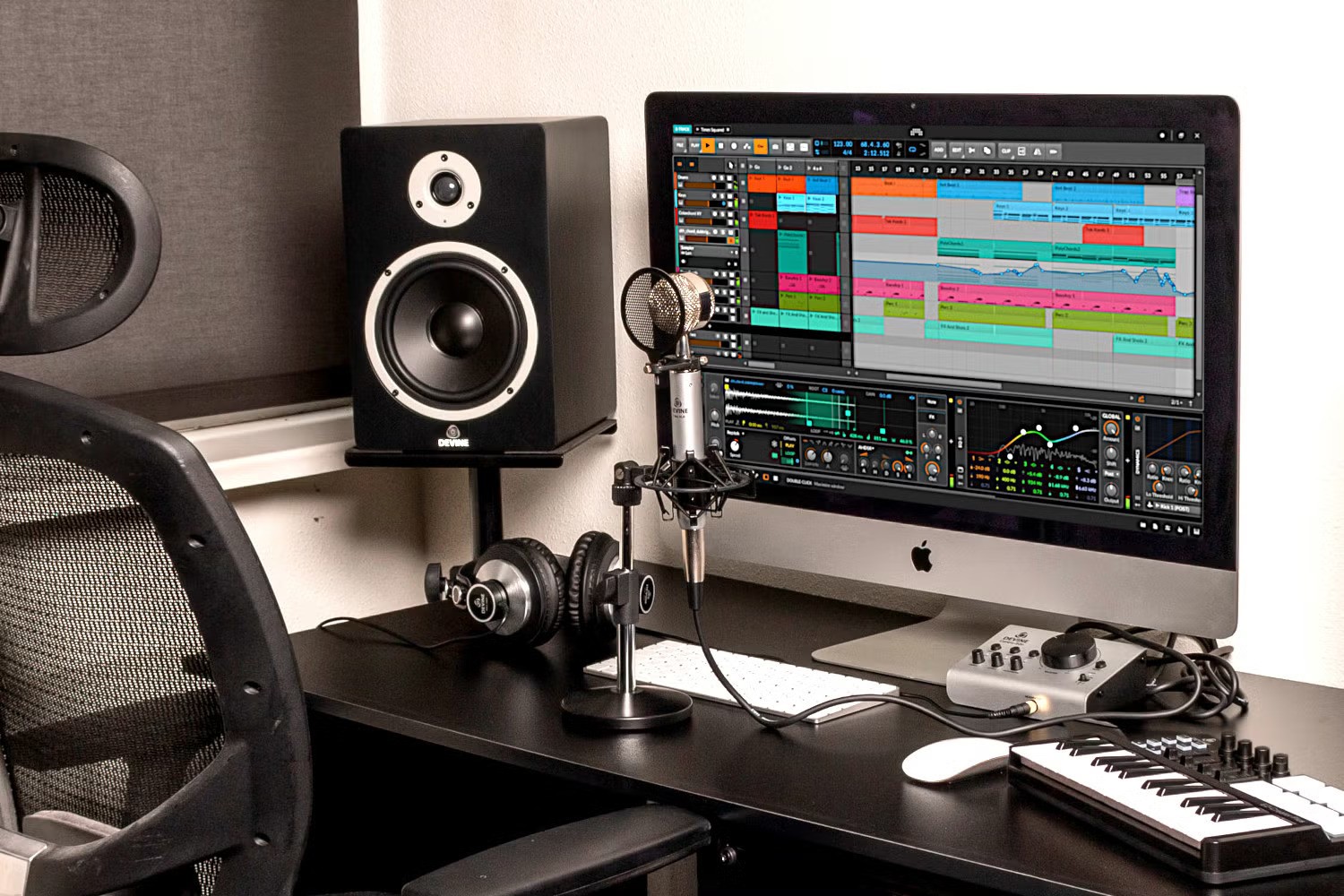 Home music production setup with computer, studio monitors, MIDI keyboard, and audio interface