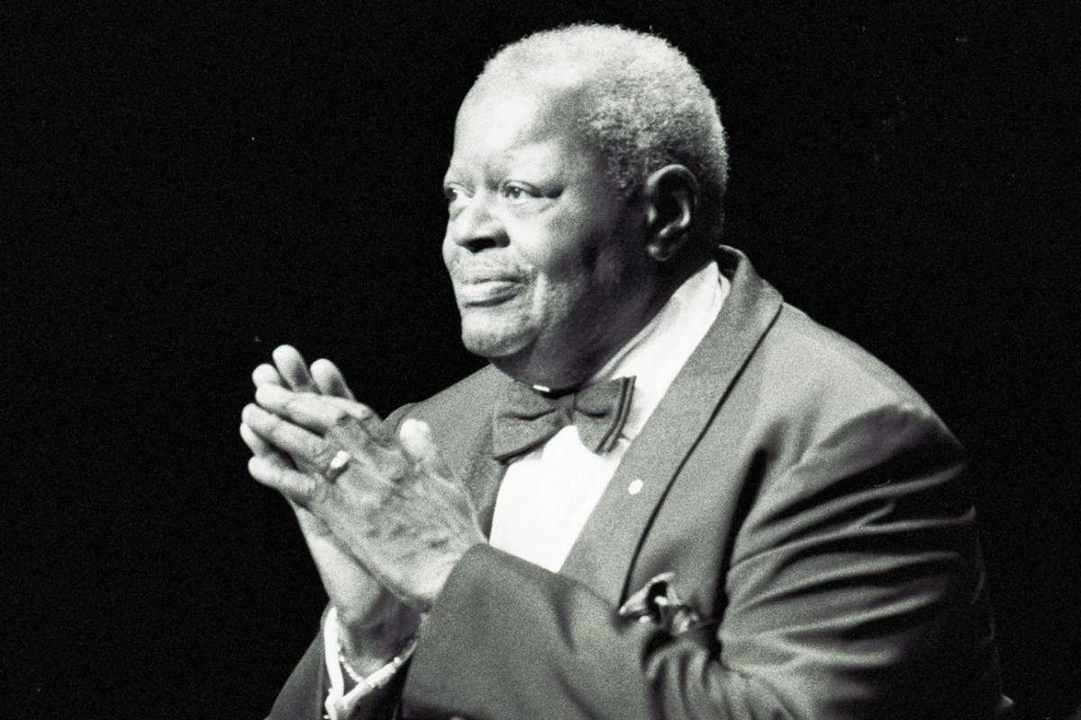 Elderly blues musician applauding during formal stage performance