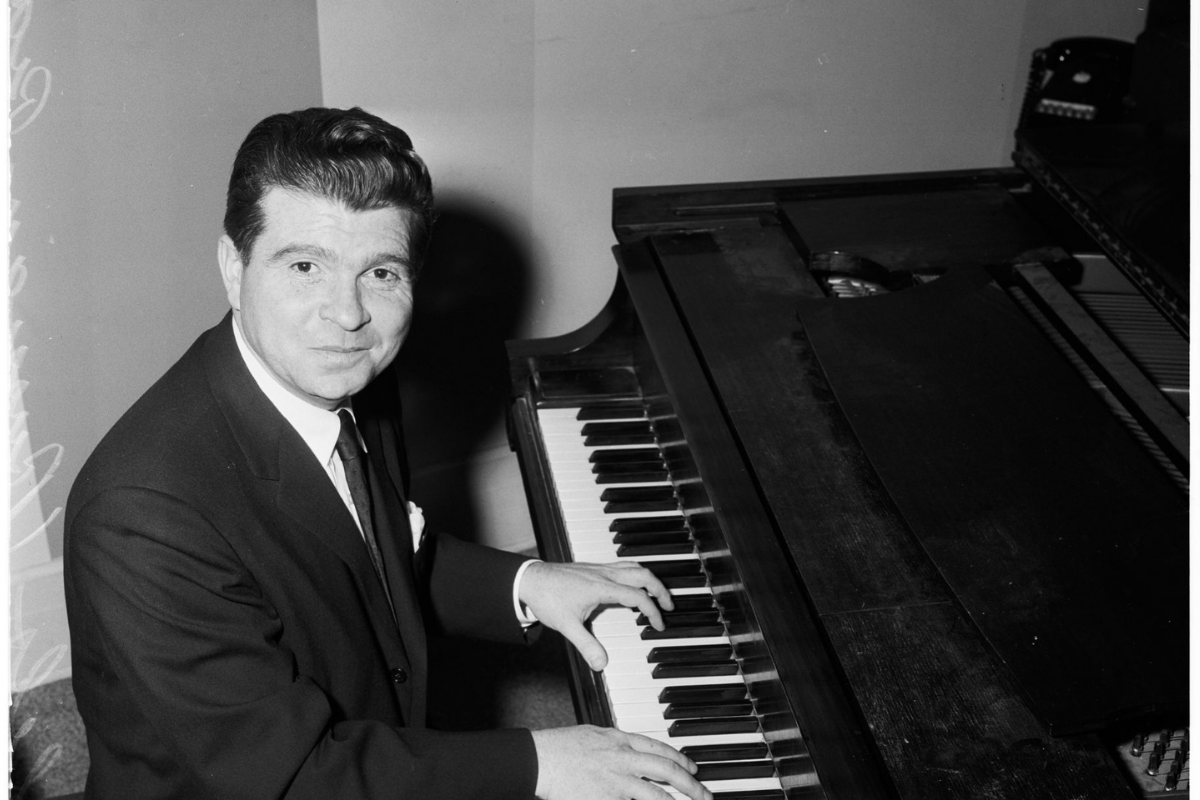 Man playing grand piano in vintage black-and-white photograph