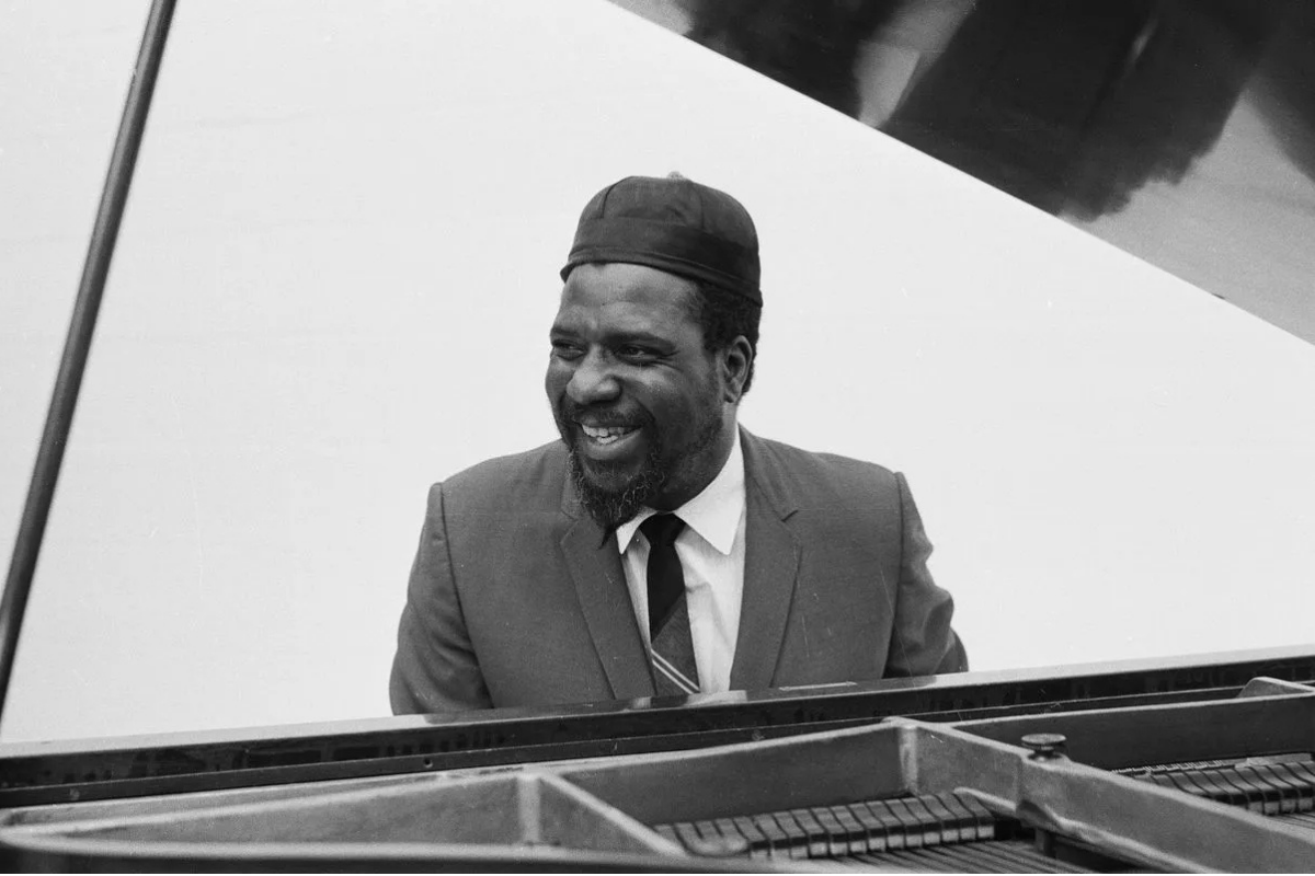 Smiling jazz pianist seated behind grand piano