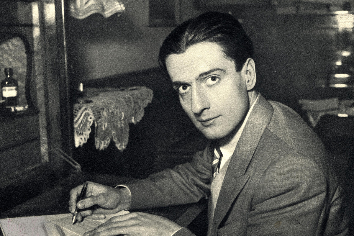 Young man writing at desk in formal attire