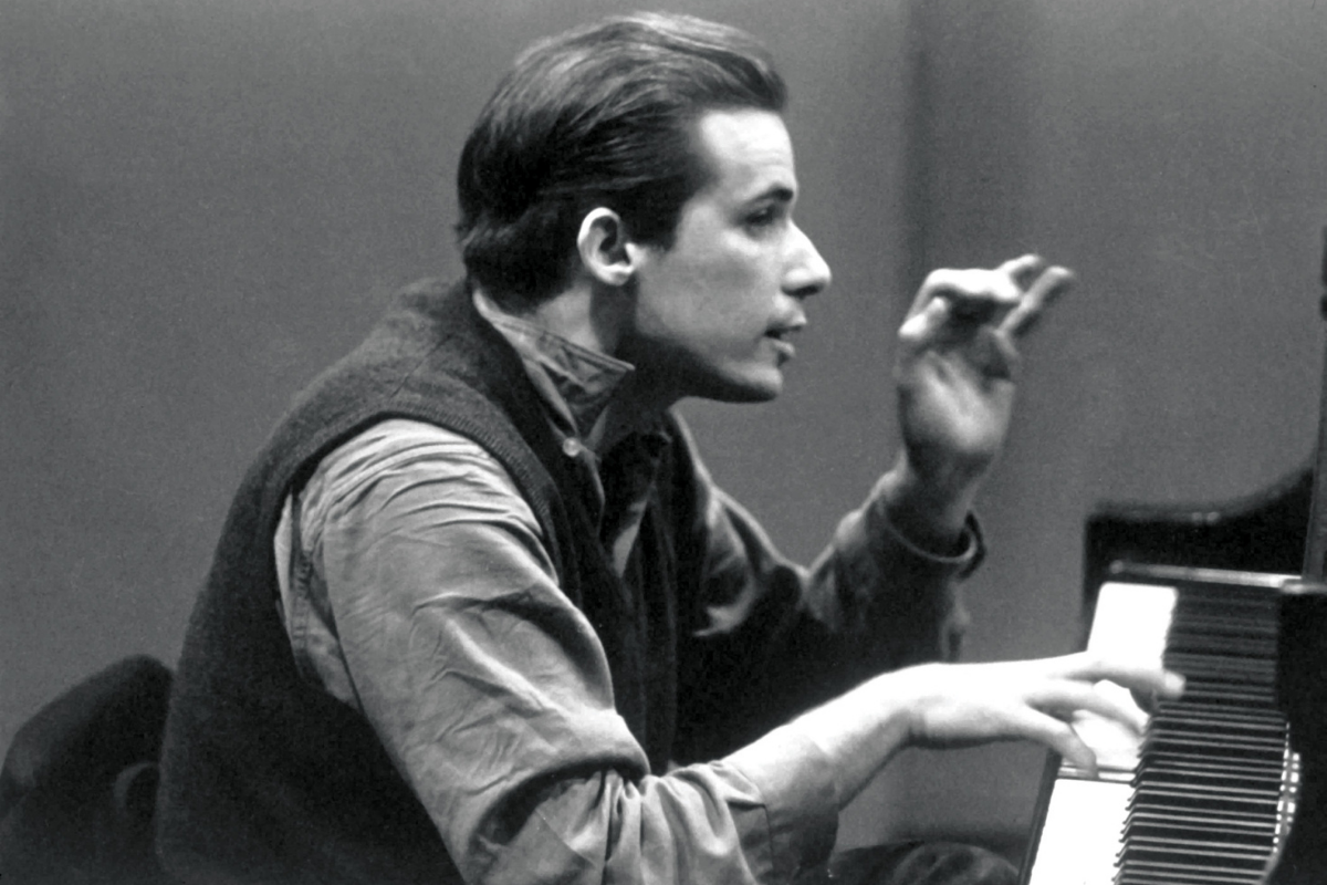 Young pianist gesturing while seated beside piano keyboard
