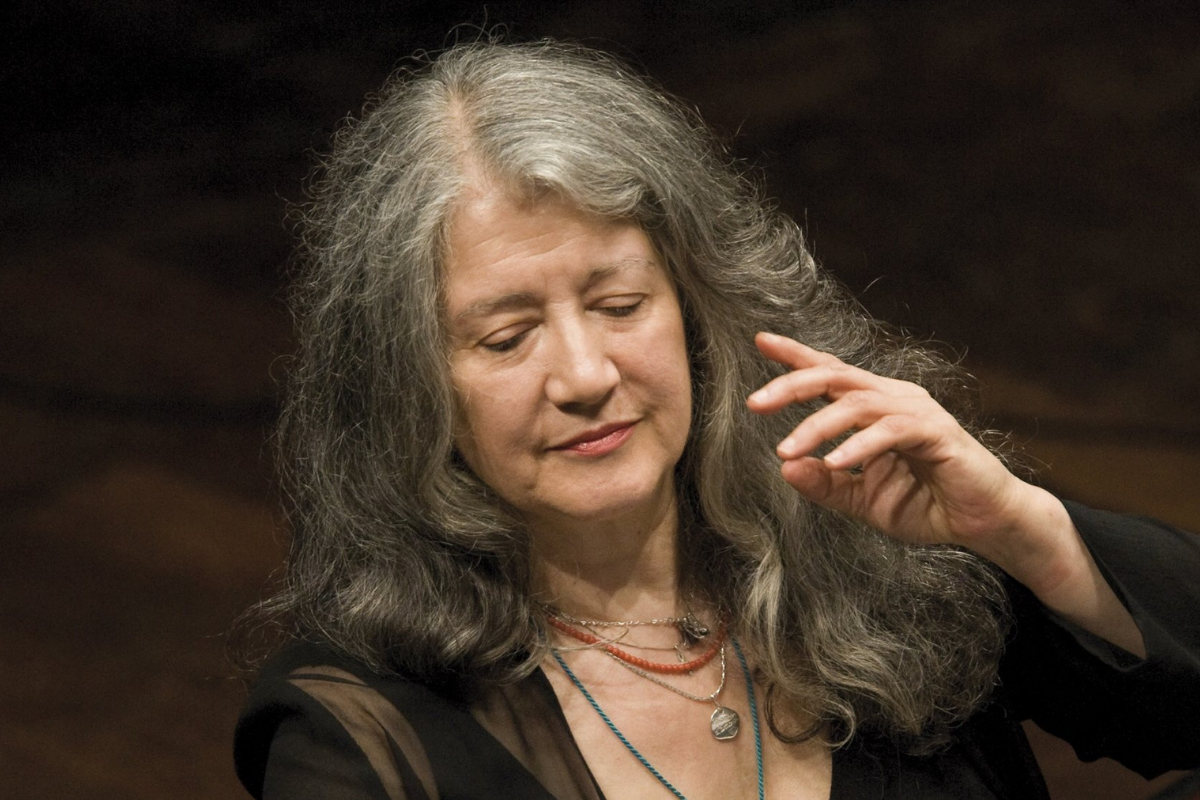 Woman with gray hair gesturing during musical performance