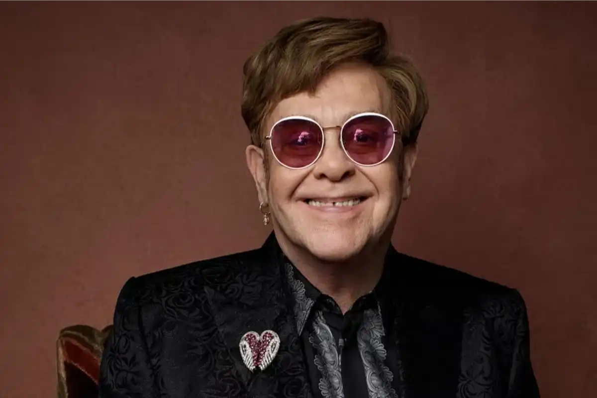Smiling man wearing pink sunglasses and black blazer